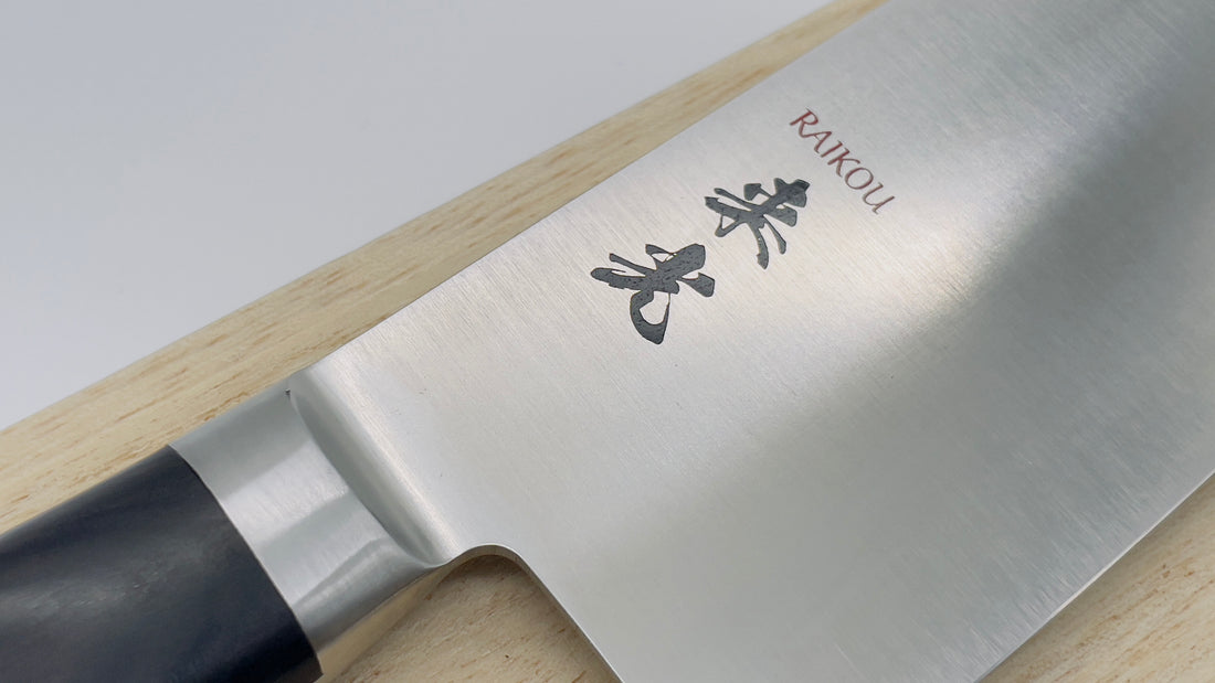 Up close image of a Santoku knife showing the brand labeling Raikou