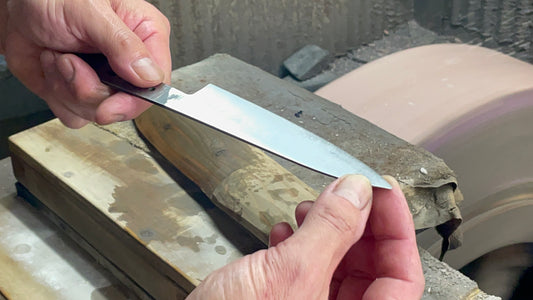 Japanese artisan holding recently hand sharpened petty knife