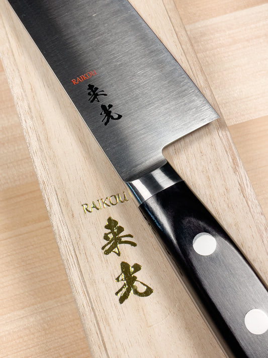 Raikou santoku chef knife, knife sits atop product packaging